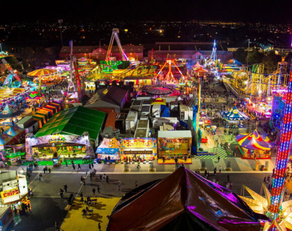 Carnival at night, full of rides and tents that have bright colours and are well lit (Royal Adelaide Show)
