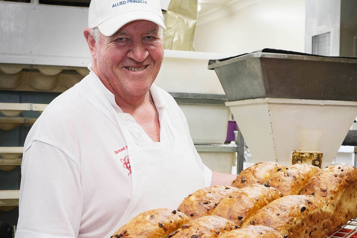 Stewart Latter holding a tray of bread loaves straight out of the oven