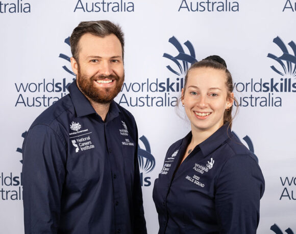 Fourth-place winner Rachel Crawford stands next to coach John Reminis in front of a WorldSkills Australia banner (WorldSkills Championship)