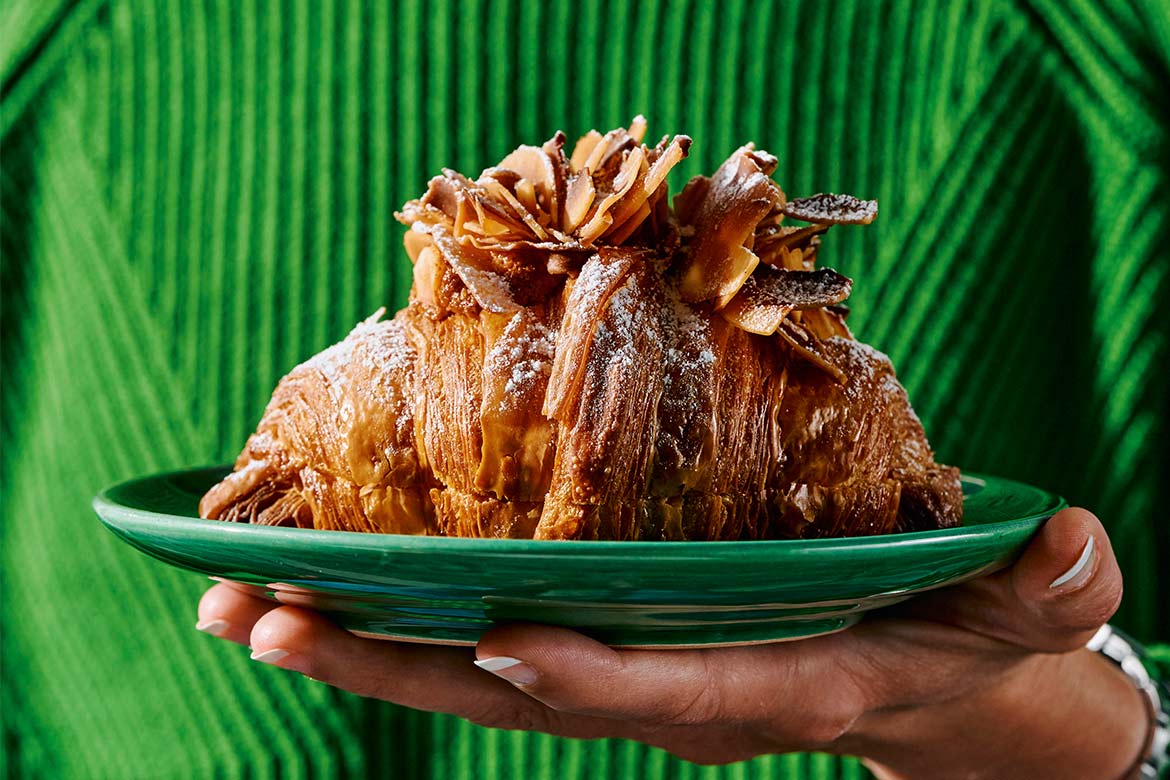 Coconut pandan twice baked croissant rests on a green plate