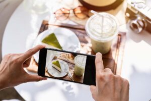 A person takes a picture of their food at a cafe (influencer culture)