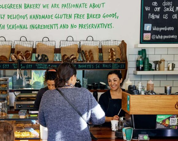 A woman at a bakery counter pays a cashier for her purchase (Wholegreen Bakery)