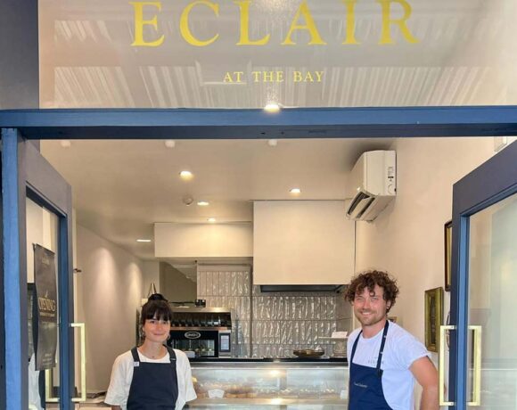 Pavel and Mary standing in front of the Eclair at the Bay shopfront