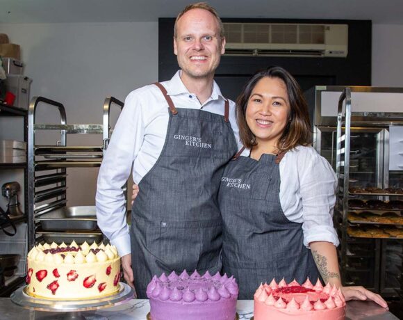 Ginger Mendoza and husband Soren Andersen stand in front of cakes (Batch Cookie Bar)