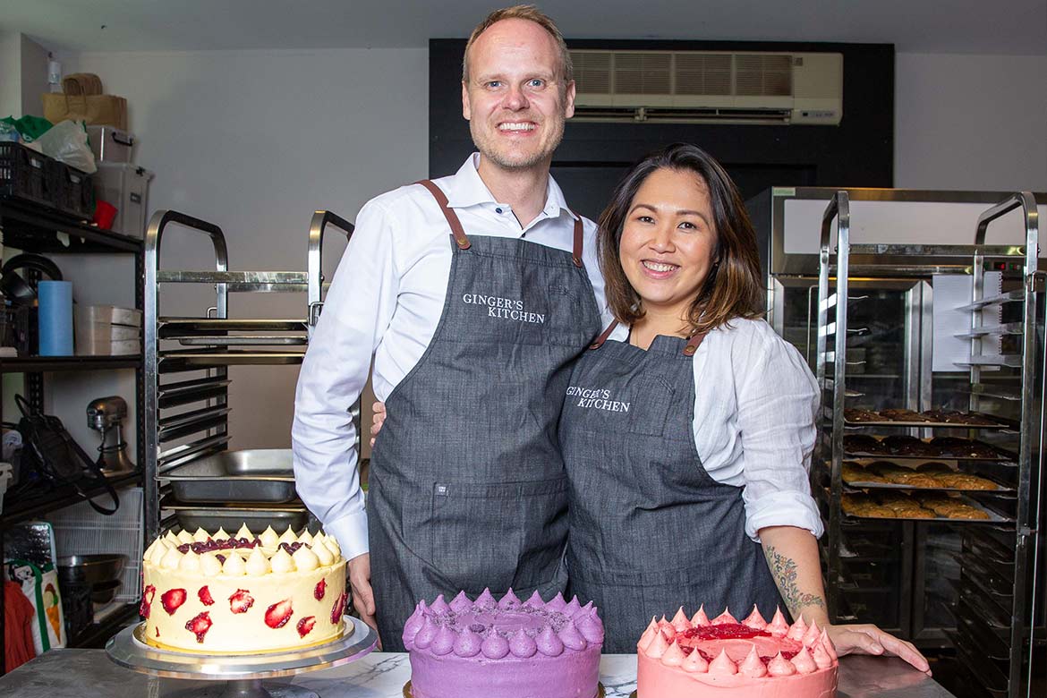 Ginger Mendoza and husband Soren Andersen stand in front of cakes (Batch Cookie Bar)