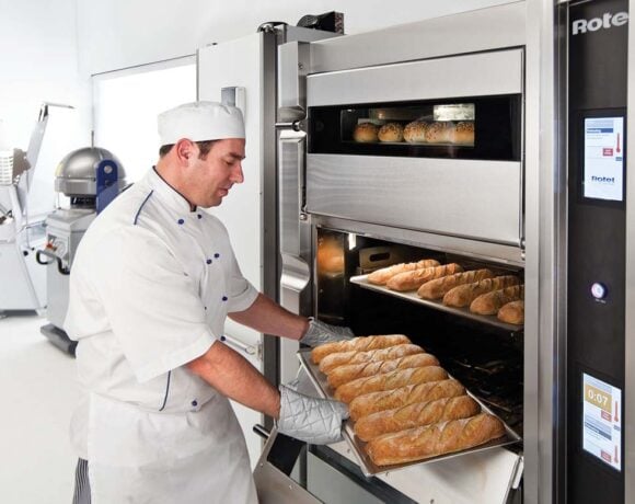 A baker pulling a tray of loaves out of the Rotel 3