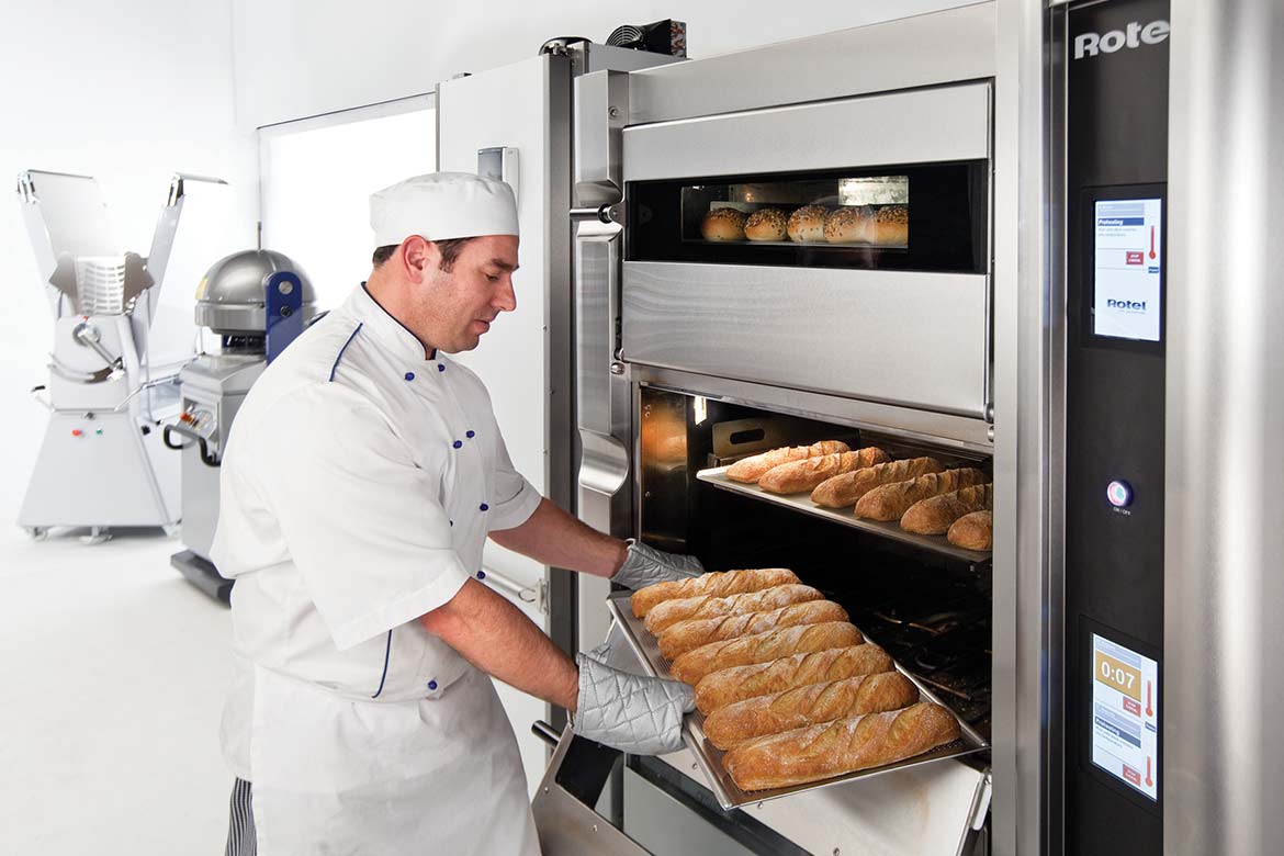 A baker pulling a tray of loaves out of the Rotel 3
