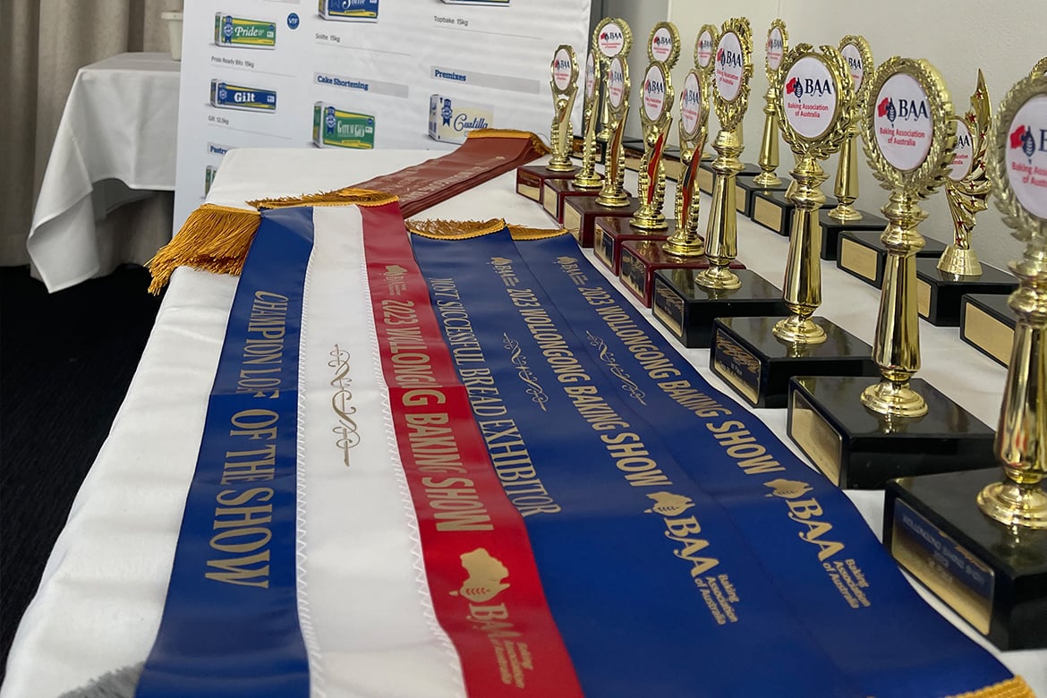 a table full of sashes and trophies for the Wollongong Baking Show 2023