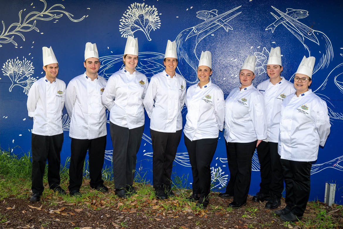The Youth team for the Culinary Olympics is pictured in chef whites standing against a dark blue wall. Stephanie Lawler is the Tasmanian pastry chef.