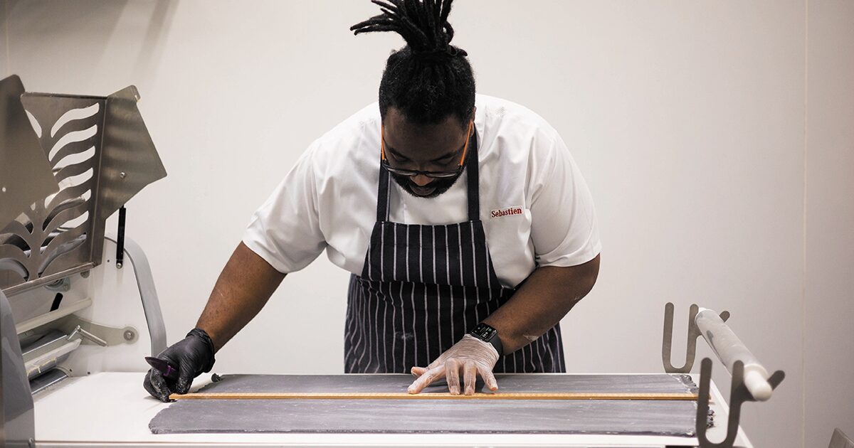 Sebastian syidalza rolling out pastry in his bakery 