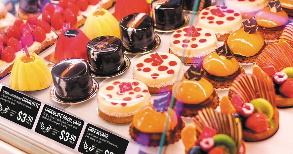 Interactcard signs can make all the difference. Pictured is a fine pastry display case filled with colourful pastries. In front of each line of pastries is a black card with white writing showing the name and price of each pastry.
