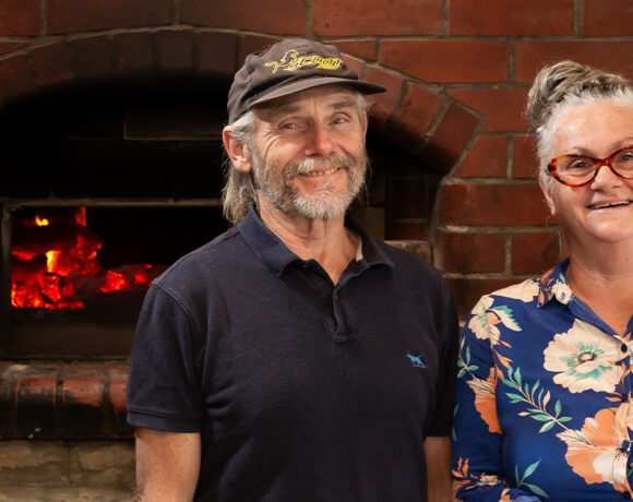 Summer Kitchen Bakery owners John and Marie stand in front of the woodfired oven