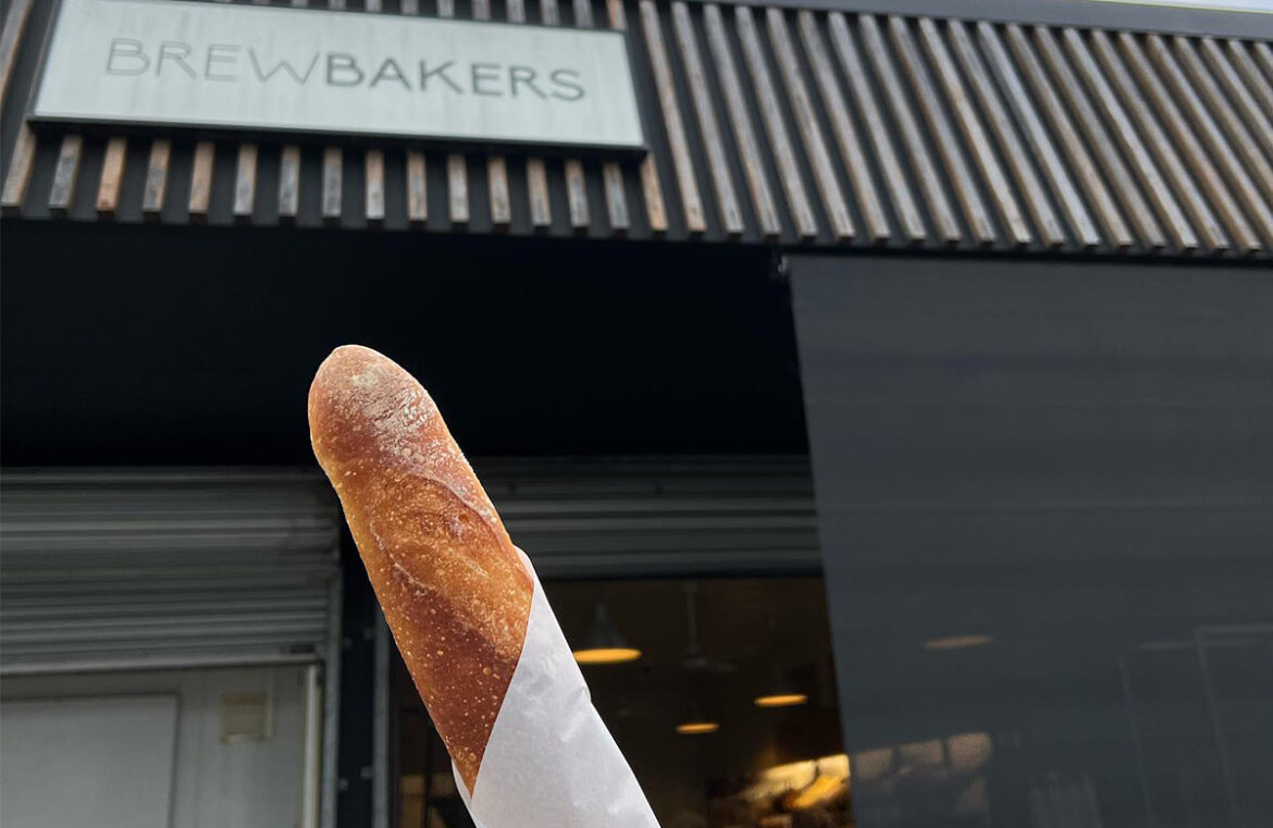 Brewbakers shopfront with a baguette in paper in focus.