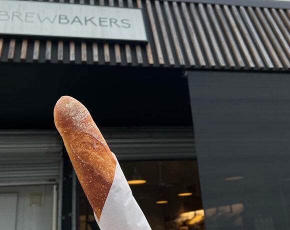 Brewbakers shopfront with a baguette in paper in focus.