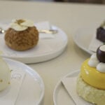 Desserts sit on white plates at Sanshi Patisserie