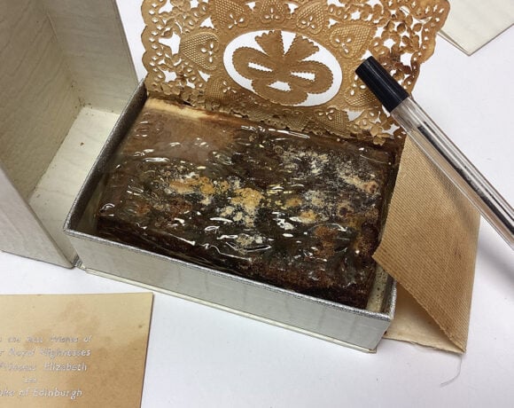 The slice of Queen Elizabeth II's wedding cake has survived almost eight decades. Pictured is the fruit cake in its original tin packaging, with a paper card sitting next to it.