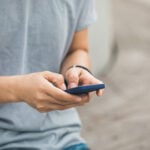 To what degree can employees express discontent with employer decisions ? Pictured is a hand holding a mobile phone. The person is typin gon the screen with their thumbs